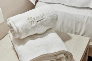 a pile of towels sitting on top of a bed at Kalsa Sicilian Rooms in Partinico