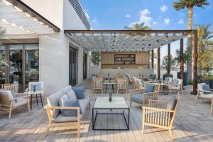 Address Beach Resort Fujairah في العقة: فناء به طاولات وكراسي ومطعم