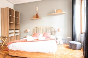 een slaapkamer met een bed met witte lakens en roze kussens bij Spacieux - La Galerie - Gare in Straatsburg