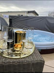 uma bandeja de taças de vinho e uma banheira de água em Hot tub breaks Fairways Tattershall lakes em Tattershall