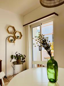 un jarrón verde con flores sentado en una mesa en Encantador apartamento en Tossa de Mar, en Tossa de Mar