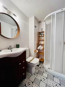 y baño con aseo, lavabo y espejo. en Encantador apartamento en Tossa de Mar en Tossa de Mar
