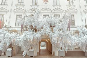 een wit gebouw met een boog met witte bloemen bij Hotel Pacai, Vilnius, a Member of Design Hotels in Vilnius