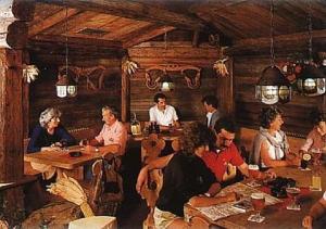 people sitting around a wooden table at Hotel Cristallo in Vigo di Fassa