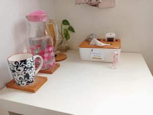 - un comptoir de cuisine avec une carafe, une tasse et une boîte dans l'établissement 拉瓦宅 輕旅店 - Lawa House, à Chiayi