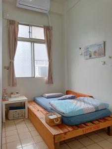 1 dormitorio con cama de madera y ventana en 拉瓦宅 輕旅店 - Lawa House, en Chiayi