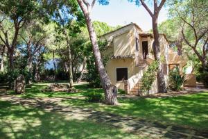 ein Haus mit einem Baum im Hof in der Unterkunft Baia Delle Palme Beach in Santa Margherita di Pula