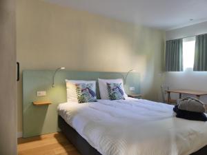 a bedroom with a large bed with two pillows at Het Zilte in Zuidzande