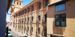 un vecchio edificio con una torre dell'orologio su una strada di ALMAALQUILER Gran Maestre 3 ad Almagro