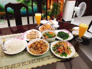 una mesa con platos de comida y bebidas. en B & B Accommodation Service, en Hoi An