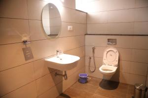 a bathroom with a sink and a toilet at Royal Indraprastha The Hotel in Bengaluru