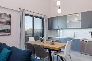 cocina y comedor con mesa de madera y sillas en Aurora apartments, en La Canea