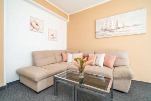 a living room with a couch and a glass table at Apartments Blažević in Mlini