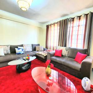 a living room with a couch and a table at Cozy Nest-2 Bedroomed Apartment WiFi ,Netflix close to JKIA in Syokimau