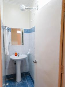 a white bathroom with a sink and a mirror at Cozy Nest-2 Bedroomed Apartment WiFi ,Netflix close to JKIA in Syokimau