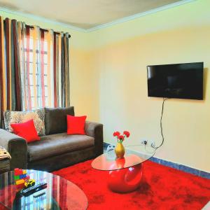 a living room with a couch and a table at Cozy Nest-2 Bedroomed Apartment WiFi ,Netflix close to JKIA in Syokimau