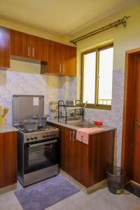a kitchen with a stove and a sink at Lux Suites Greatwall Gardens Apartments in Machakos