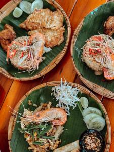 a table with three plates of food on leaves at Green Garden in Bang Rak Beach