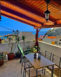 einen Tisch und Stühle auf einer Terrasse mit Meerblick in der Unterkunft House Marina in Paránimfoi