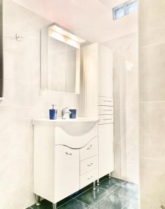 a white bathroom with a sink and a shower at House Marina in Paránimfoi