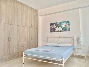 a bedroom with a bed and wooden cabinets at House Marina in Paránimfoi