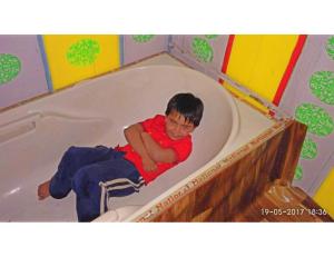 a young boy laying in a bath tub at Blue heaven House boat, Srinagar in Srinagar