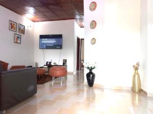 a lobby with a couch and a table and a tv at Résidences MAFCA in Conakry