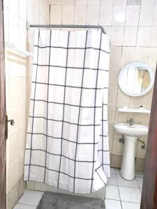 ein Badezimmer mit Duschvorhang und Waschbecken in der Unterkunft Résidences MAFCA in Conakry + 12 Fotos
