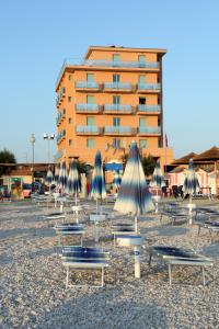 un grupo de sillas y sombrillas en una playa en Abbazia Club Hotel Marotta, en Marotta