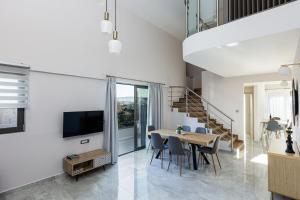 una sala da pranzo e un soggiorno con tavolo e sedie. di Aurora apartments a Chania