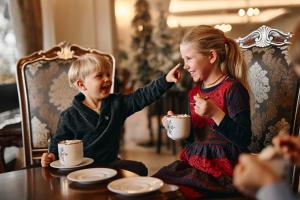 two young children sitting at a table eating food at Hotel Bellevue - Liburnia in Opatija