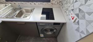 een keuken met een wastafel en een wasmachine bij STAY Nissi Twins Apts in Ayia Napa