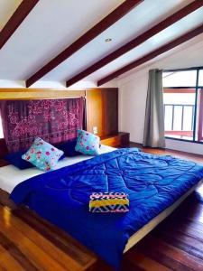 un grande letto con lenzuola e cuscini blu in una camera da letto di Koi Seahouse a Ko Chang