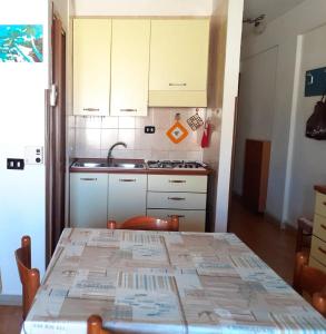 a small kitchen with a table and a sink at CASA MARINA in Lampedusa