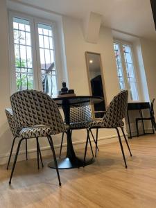 duas cadeiras e uma mesa numa sala com um piano em Appartement chaleureux em Dijon