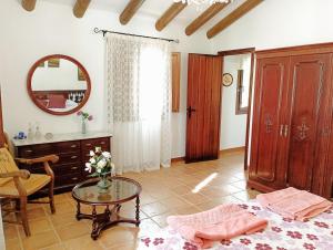 um quarto com uma cama, uma mesa e um espelho em Casa rural Carratraca Finca Los viñazos em Carratraca