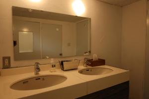 ein Badezimmer mit zwei Waschbecken und einem großen Spiegel in der Unterkunft Guest House Ichiyama Shukuba in Matsumoto