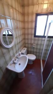 uma casa de banho com um WC, um lavatório e um espelho. em Casa Rural Doña Catalina em Jimena de la Frontera