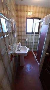 uma casa de banho com um lavatório branco e uma janela em Casa Rural Doña Catalina em Jimena de la Frontera