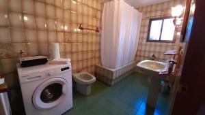 een badkamer met een wasmachine, een toilet en een wastafel bij Casa Rural Doña Catalina in Jimena de la Frontera