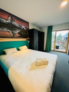レ・デュー・アルプにあるThe People - Les 2 Alpesのベッドルーム1室(大型ベッド1台、タオル付)