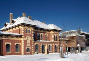 a large brick building with snow on top of it at Lillehammer Hostel in Lillehammer