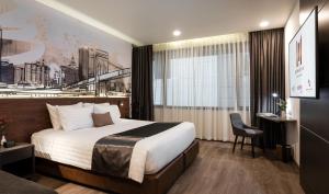 バンコクにあるManhattan Hotel Bangkokの大きなベッドと椅子のあるホテルの部屋 +59枚の写真