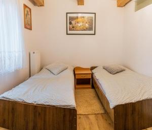 two twin beds in a room with a window at Beskidzki Klimat Jaśliska in Jaśliska