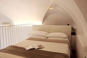 a bedroom with a bed with a book on it at kaDevi piazza Bresca - pieno centro, parcheggio, bici in Sanremo