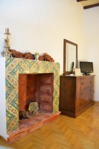 a room with a fireplace with a dresser and a mirror at Casa Magiuli' Navona in Rome
