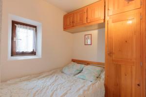 um pequeno quarto com uma cama e uma janela em Equiria - 1 chambre - balcon em Saint-Léger-les-Mélèzes