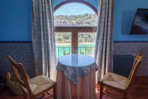 ein Tisch und zwei Stühle in einem Zimmer mit Fenster in der Unterkunft Hotel Rural Albamanjon in Ruidera