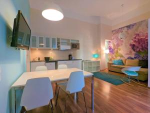 a kitchen and a living room with a table and chairs at Flora's House - Stylish, central one bedroom in Budapest