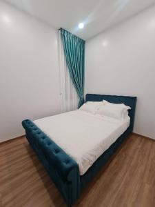 een bed met een blauw bedframe in een kamer bij EG Home - The Cove Hillside Residence in Ipoh